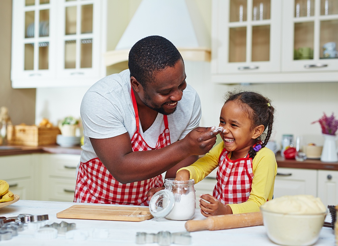 Personal Insurance - Happy Father and Daughter Prepare to Bake and Play With Flour in the Kitchen